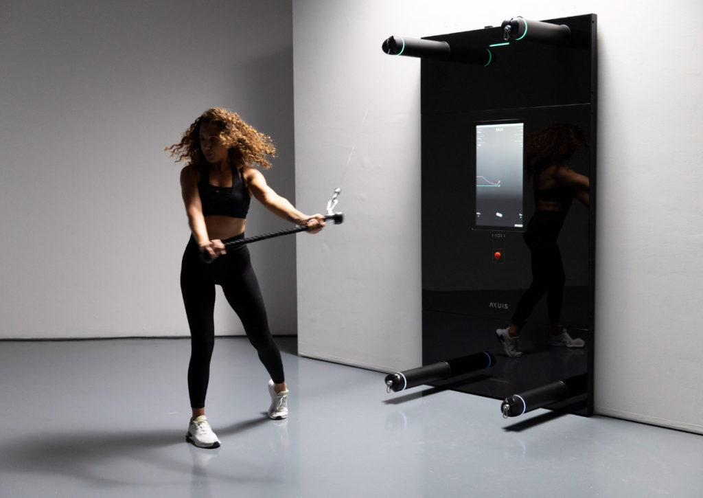 Donna in tenuta atletica utilizza una macchina a cavi in uno spazio palestra minimalista in palestra digitale.
