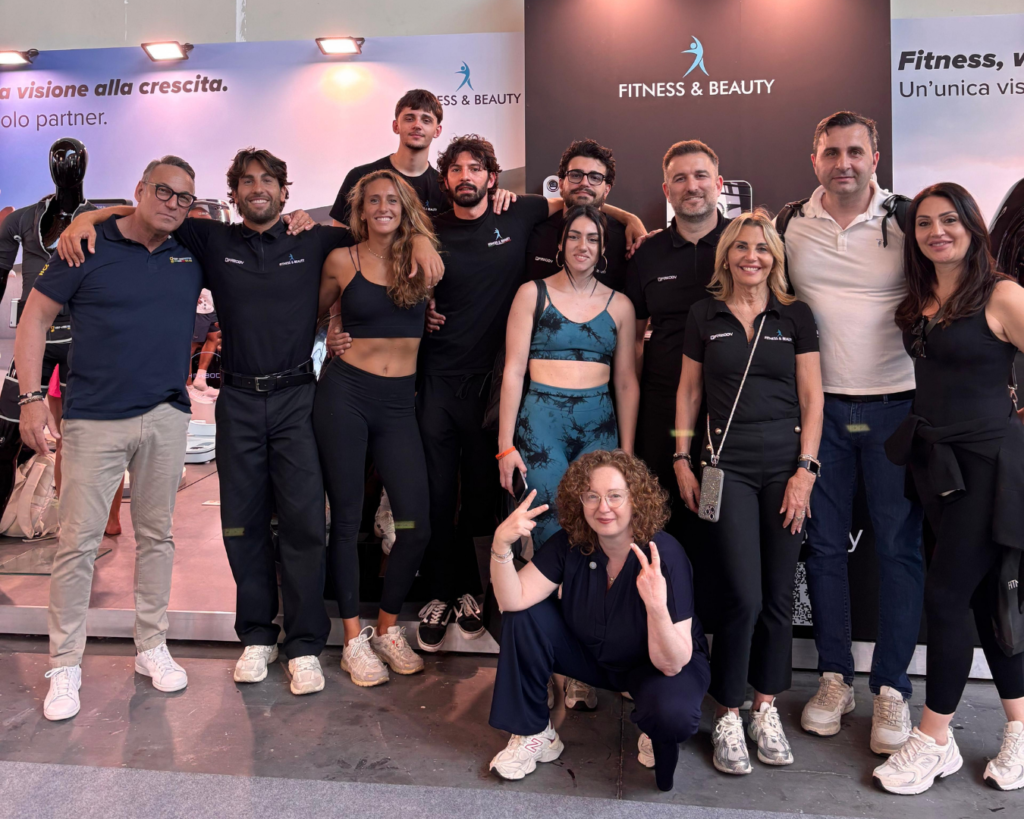 Un gruppo posa davanti all'esposizione "Fitness & beauty a RiminiWellness | 28 - 31 Maggio 2026".
